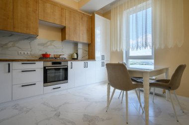 Sarı mutfak, sarı duvarlı ve beyaz mermer zeminli modern beyaz ve ahşap mobilyalar.