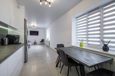 Luxurious modern trendy white and grey kitchen interior after renovation, with granite counter top