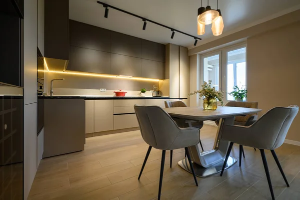 Modern grey luxurious kitchen in studio apartment interior, closeup to dining table