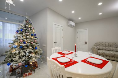 Parlak yemek odasının içi Noel ağacıyla süslenmiş.