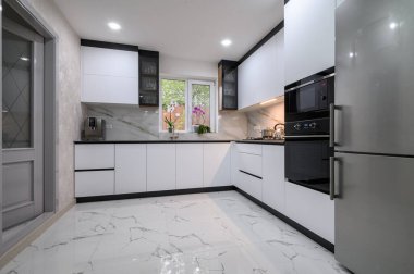 Yakın zamanda yenilenmiş, modern aletleri, mermer zemini ve modern kaplamaları olan bir mutfak.