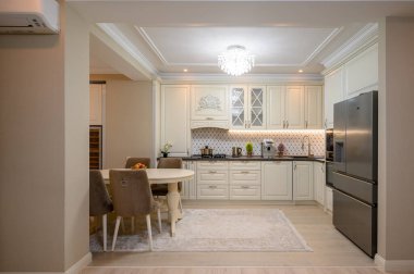 Geniş tezgahı ve çeşitli aletleri olan klasik bej mutfak.