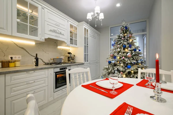 クリスマスツリーで飾られたダイニングテーブルと明るいモダンなキッチンのインテリア — ストック写真