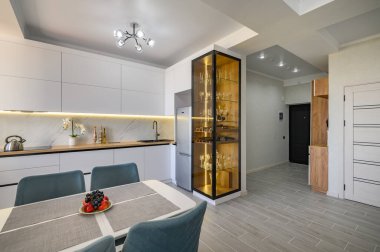 Tam teçhizatlı ve kullanıma hazır bir mutfağı olan modern beyaz bir stüdyo.