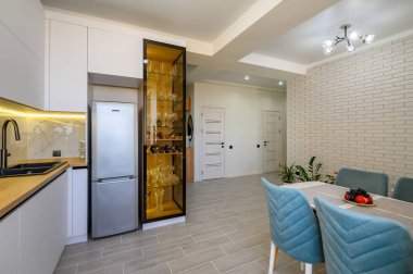 Mutfağı, yemek masası ve büfesi olan modern bir minimalist beyaz stüdyo.