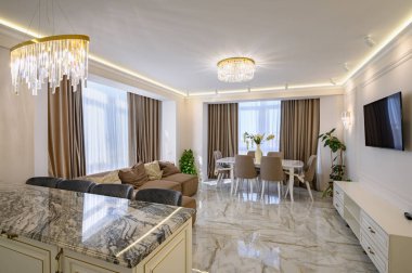 Klasik mutfak ve oturma odası krem renginde. Geniş ve parlak bir tasarımı var. Bir ada ve yemek alanı dahil.