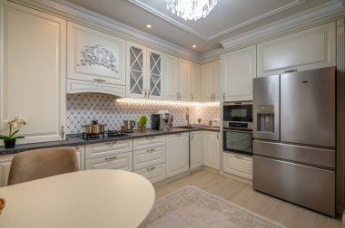 Geniş tezgahı ve çeşitli aletleri olan klasik bej mutfak.