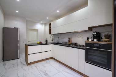 Geniş beyaz ve siyah mutfak, bir sürü fotokopi alanı.