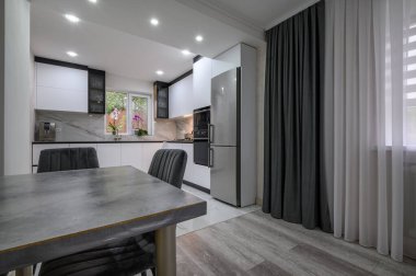 Güzel, beyaz bir mutfağı ve yemek odası olan ve modern ve işlevsel olması için yenilenmiş bir stüdyo daire.