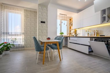 A modern simple white kitchen with drawers pulled out to their full length