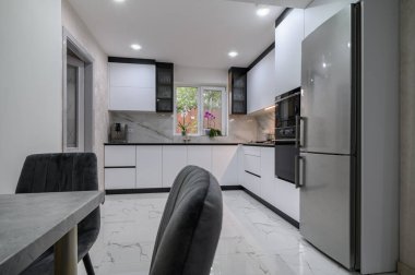 Güzel, beyaz bir mutfağı ve yemek odası olan ve modern ve işlevsel olması için yenilenmiş bir stüdyo daire.