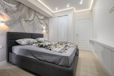 Gri yatak odasının şık, rahat çift kişilik yatağı var.