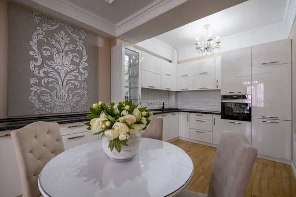 Luxury white modern kitchen with round dining table in studio apartment