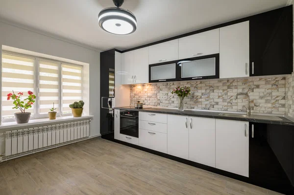 Interior renovation showcase of well designed modern trendy white kitchen, corner view