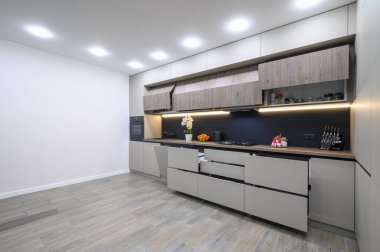 Trendy large grey modern kitchen interior showcase, minimalistic furniture with drawers retracred