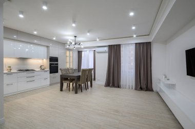 Büyük, yeni, iyi tasarlanmış beyaz mutfak stüdyo dairesinin yenilenmesinden sonra, panoramik pencereler perdelerle kaplı, bir sürü fotokopi alanı.