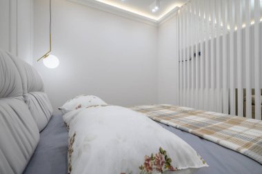 Gri ve beyaz yatak odasının şık iç tasarımı, rahat çift kişilik yatak.