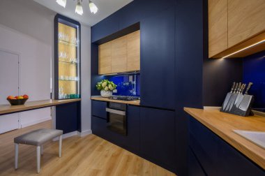 Stylish large blue and wood colored studio apartment with kitchen open to living room after good renovation
