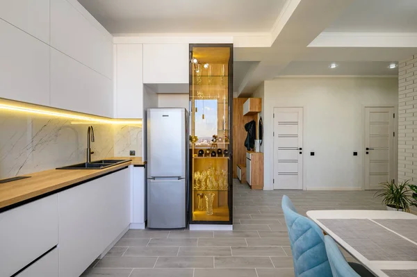 A modern white studio with a kitchen that is fully equipped and ready to use