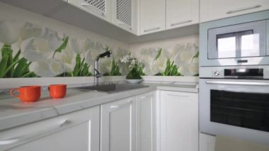 Dolly out shot of white trendy moden kitchen details at countertop