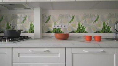 Sliding shot of white trendy moden kitchen details and appliances at countertop