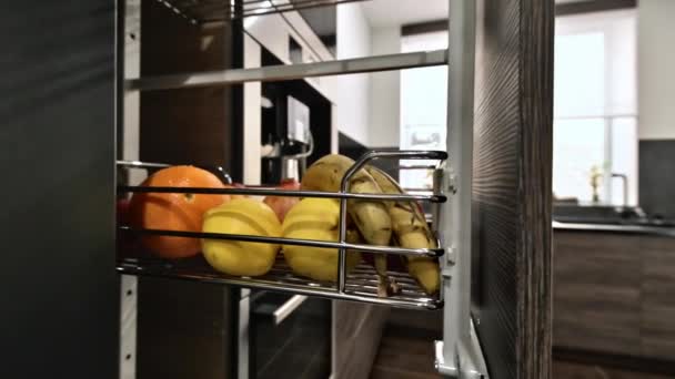 在现代深褐色 灰色和黑色厨房的垂直货架上有水果和工作台特写 — 图库视频影像