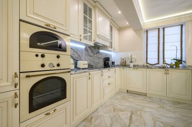 Closeup of classic cream-colored kitchen with oven, microwave, and coffee maker