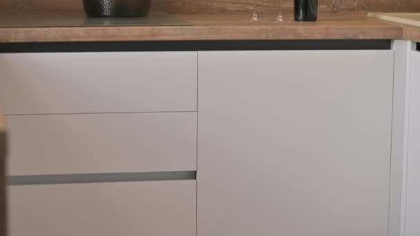 現代的な白と木製のベージュのキッチンインテリアの傾きのクローズアップビューは 台所用品や道具 フラットプロファイルショットで上から下に — ストック動画