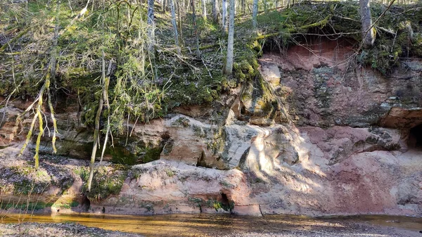 ラトビアのゴーヤ国立公園のクベセレ自然歩道の川のランチンによるサウルスタリ崖と洞窟 — ストック写真