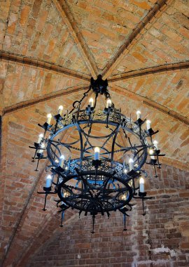 Trakai Kalesi 'nin eski kulesinde eski bir avize. Eski Lamba Tuğla Tavanda Asılı