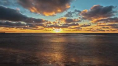 Baltık Denizi 'nin Sunset, Pavilosta, Letonya' daki Timelapse Manzarası. Sahildeki Deniz Burnu 'nun Üzerinde Güzel Altın Gün Batımı. Parlayan Güneş Işığı Yansıması. Courland 'daki Saka Nehri' nin ağzındaki Baltık Denizi