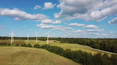 Rüzgâr Çiftliği 'nin ya da Rüzgâr Parkı' nın Havadan Görünümü 'nde jenerasyon elektriği için yüksek rüzgar türbinleri var. Kırsal bölgedeki Enerji Çiftliği Rüzgârı Türbinleri. Letonya 'da güzel bir yaz günü. Yeşil Enerji Konsepti.