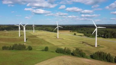Rüzgâr Çiftliği 'nin ya da Rüzgâr Parkı' nın Havadan Görünümü 'nde jenerasyon elektriği için yüksek rüzgar türbinleri var. Kırsal bölgedeki Enerji Çiftliği Rüzgârı Türbinleri. Letonya 'da güzel bir yaz günü. Yeşil Enerji Konsepti.