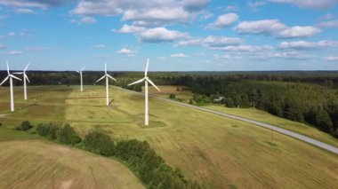 Rüzgâr Çiftliği 'nin ya da Rüzgâr Parkı' nın Havadan Görünümü 'nde jenerasyon elektriği için yüksek rüzgar türbinleri var. Kırsal bölgedeki Enerji Çiftliği Rüzgârı Türbinleri. Letonya 'da güzel bir yaz günü. Yeşil Enerji Konsepti.