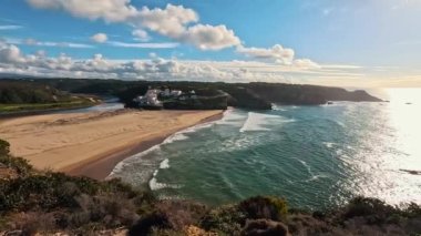 Praia De Ohexe Mar Sahili Altın Kum, Atlantik Okyanusu, Nehir Bükme ve Aldatma Köyü 'nün Beyaz Evleri ile. Rota Vicentina Sahili, Odemira, Portekiz. Rota Vicentina 'nın Balıkçı Patikası' nda yürüyüş.