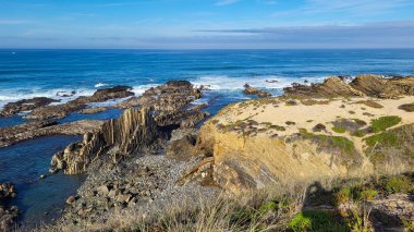 Portekiz, Alentejo Sahili 'nde siyah bazalt kayalıklı Almograve Plajı. Rota Vicentina 'nın ayak izlerinde. Yürüyüş Balıkçı Yolu.