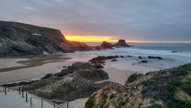 Günbatımı Zambujeira Do Mar Plajı, Alentejo, Portekiz. Portekiz Yürüyüşü Rota Vicentina Balıkçı Yolu boyunca Alentejo Kıyısı boyunca Vahşi ve Engebeli Sahillere Dar Sahil Yolları.