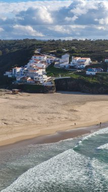 Praia De Ohexe Mar Sahili Altın Kum, Atlantik Okyanusu, Nehir Bükme ve Aldatma Köyü 'nün Beyaz Evleri ile. Rota Vicentina Sahili, Odemira, Portekiz. Rota Vicentina 'nın Balıkçı Patikası' nda yürüyüş.