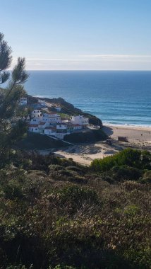 Praia De Ohexe Mar Sahili Altın Kum, Atlantik Okyanusu, Nehir Bükme ve Aldatma Köyü 'nün Beyaz Evleri ile. Rota Vicentina Sahili, Odemira, Portekiz. Rota Vicentina 'nın Balıkçı Patikası' nda yürüyüş.