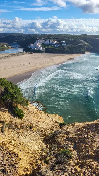 Praia De Ohexe Mar Sahili Altın Kum, Atlantik Okyanusu, Nehir Bükme ve Aldatma Köyü 'nün Beyaz Evleri ile. Rota Vicentina Sahili, Odemira, Portekiz. Rota Vicentina 'nın Balıkçı Patikası' nda yürüyüş.