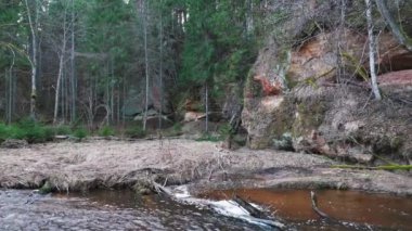 Letonya, Ieriki 'deki Cecilu Doğa Yolu. Kumada Nehri 'nin sağ kıyısından Cecilu Mağarası ve Rock Rock. Kuzey Kaya Havadan Uçan Dron Yavaş Çekiyor. Cecilu Doğa Patikası Turistler için Yürüyen Yol