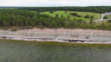 Kuressaare yakınlarındaki Saaremaa Adası 'nın kuzey kıyısı, Baltık Denizi. Saaremaa, Estonya. Panga Uçurumlarının 4K Panoramik Hava Videosu
