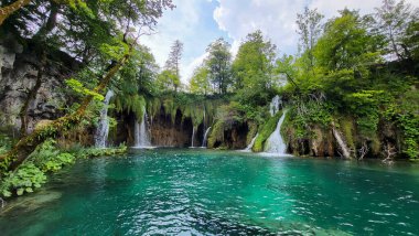 Şeffaf Turkuaz Gölün Renkli Suları Dalgalanmaya Başlıyor. Birçok küçük şelale göle akıyor. Plitvice Gölleri, Ulusal Park, Hırvat Sahnesi, Şelale Manzarası, Doğal Güzellik