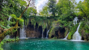 Şeffaf Turkuaz Gölün Renkli Suları Dalgalanmaya Başlıyor. Birçok küçük şelale göle akıyor. Plitvice Gölleri, Ulusal Park, Hırvat Sahnesi, Şelale Manzarası, Doğal Güzellik