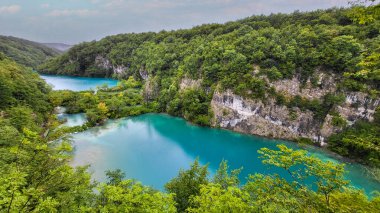 Şeffaf Turkuaz Gölün Renkli Suları Dalgalanmaya Başlıyor. Birçok küçük şelale göle akıyor. Plitvice Gölleri, Ulusal Park, Hırvat Sahnesi, Şelale Manzarası, Doğal Güzellik
