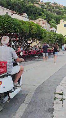 Sunset 'teki Baska Old Town' da Harbor, Yachts, Cafes ve Sea yer alıyor. Sıcak Işık, Kıyı Cazibesi ve Akdeniz Atmosferi Huzurlu ve Manzaralı Bir Anlık Yarat.