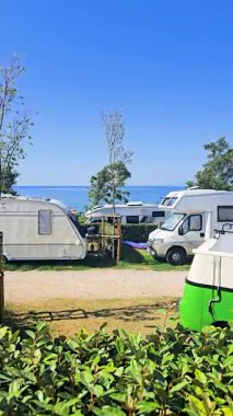 Krk Adası 'ndaki Skrila Kampı' nda güneşli bir yaz günü. Kamp Vans 'ı Deniz kenarında park etmiş, etrafı doğa ve Rocky Coastline ile çevrili. Akdeniz 'de Barışçıl Tatil Atmosferi.