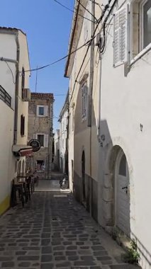 Krk Eski Kasabası 'nın Dar Caddelerinde Yürüyorum. Tarihi Taş Binalar, Akdeniz Büyüsü ve Huzurlu Atmosfer Güneşli Bir Yaz Gününde Zamansız Şehir Sahnesi Oluştur.