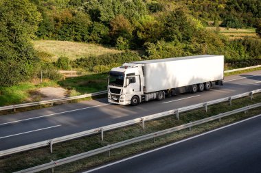 Large white Transportation Truck on a highway road through the countryside