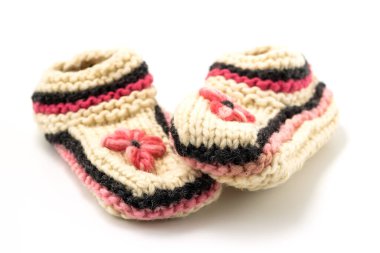 Beyaz örülmüş yün terlikler beyaz arka planda yakın plan.